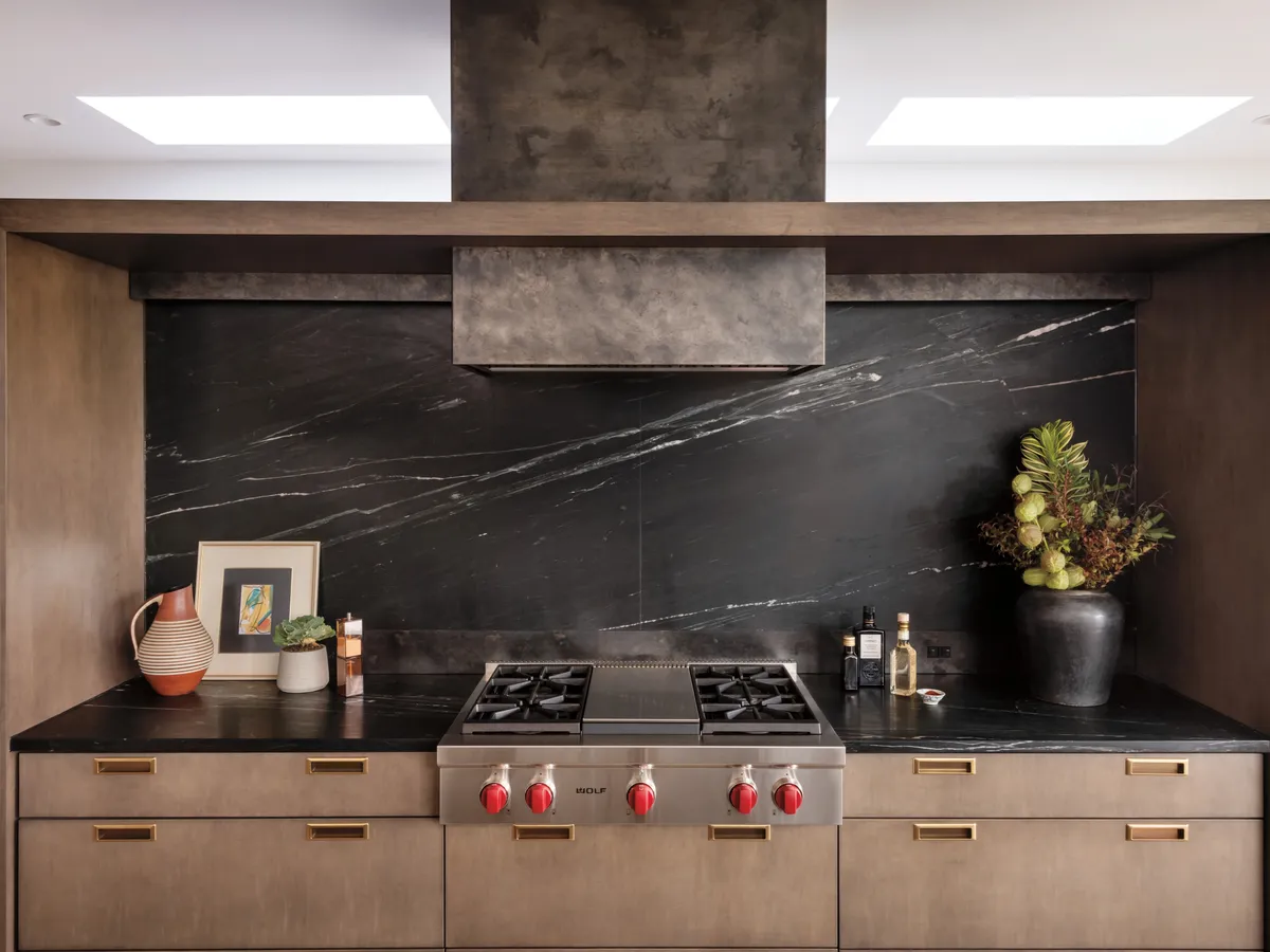 Rangetop Wolf con perillas rojas en cocina de piedra negra