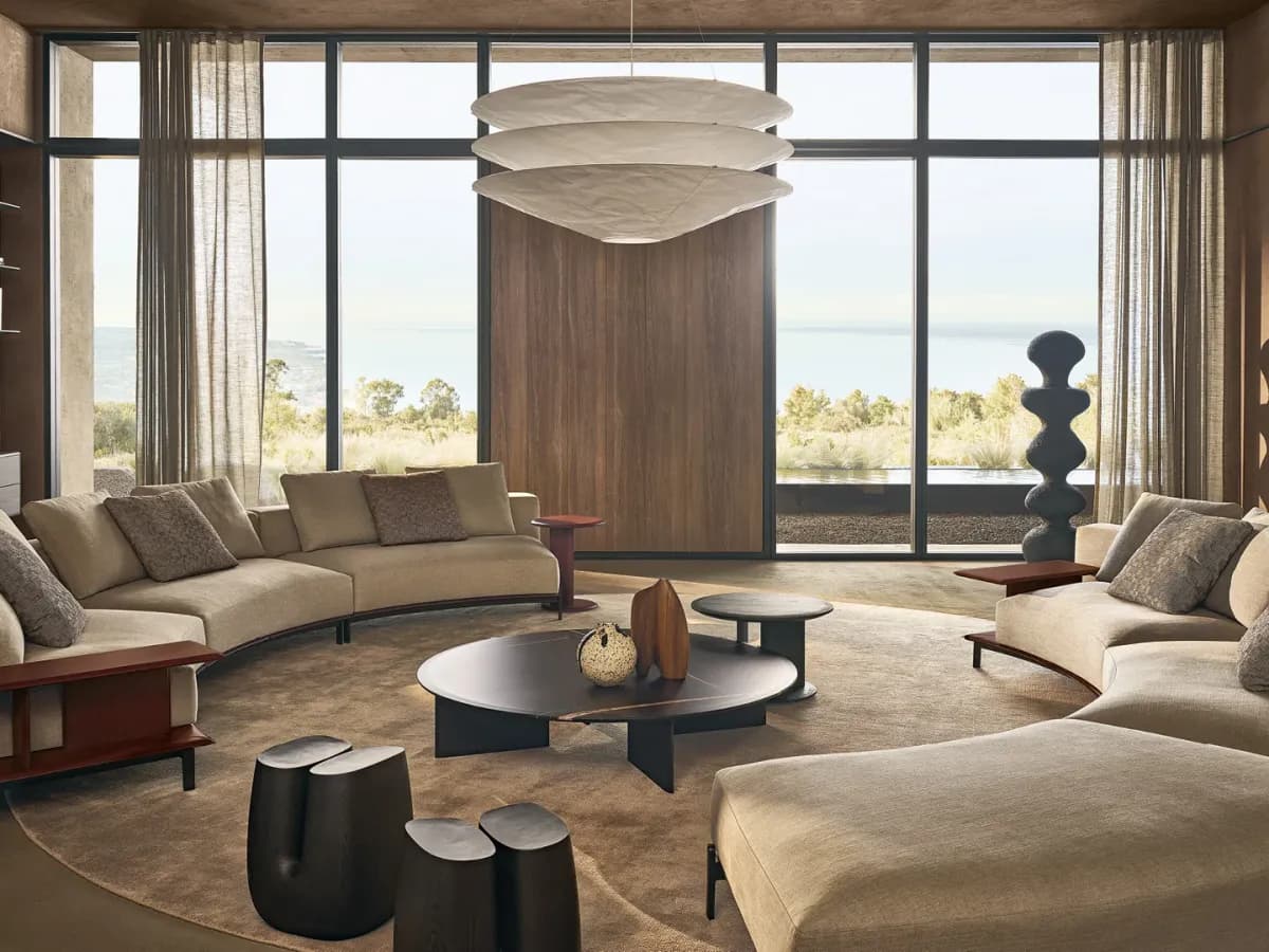 Sala Poliform con sofás curvos frente a ventanal panorámico